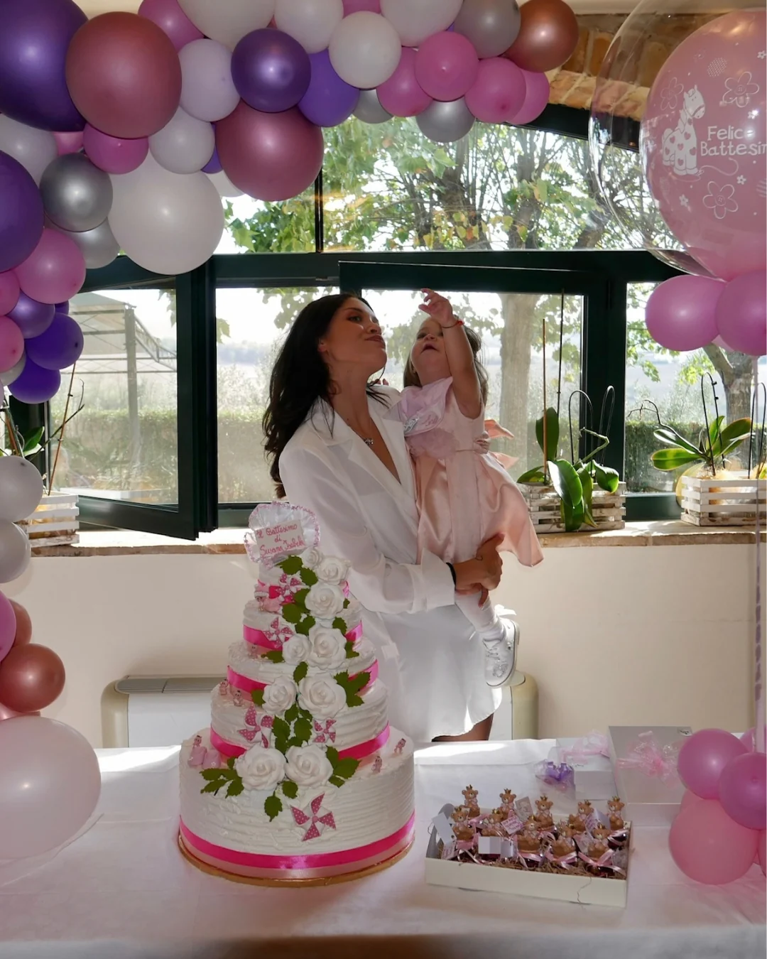 Tarta de celebración rodeada de globos.