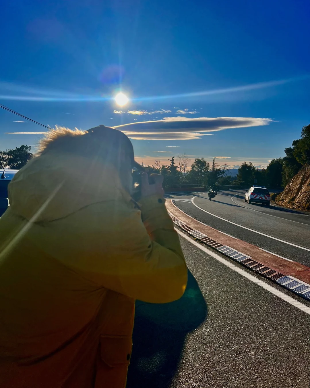 Motociclista contempla el paisaje al atardecer.